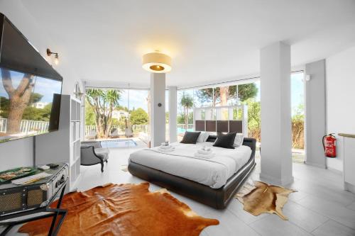 ein Schlafzimmer mit einem großen Bett und einem Fernseher in der Unterkunft VillaCINCO in Sitio de Calahonda