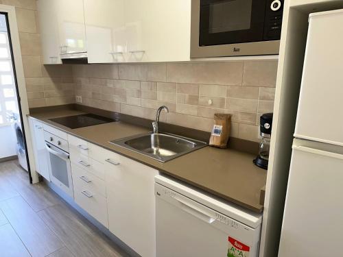 a small kitchen with a sink and a microwave at Paraiso 2 dormitorios en primera linea de mar - 333 in Pals