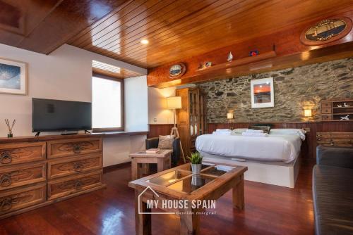 a hotel room with a bed and a tv at MyHouseSpain - Acogedor apartamento con terraza in Cudillero