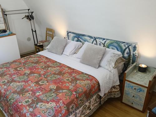 a bedroom with a bed with a colorful blanket and pillows at Little art house in Gaeta