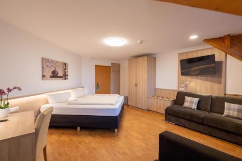 a hotel room with a bed and a couch at Wellnesshotel Sonnenhof & Sonnhalde in Ühlingen-Birkendorf