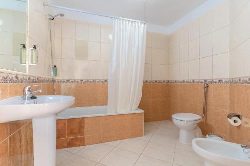 a bathroom with a sink and a tub and a toilet at HOVIMA Santa María in Adeje