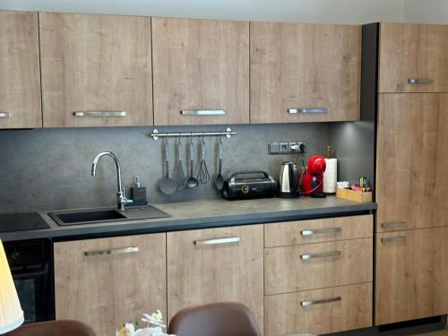 a kitchen with wooden cabinets and a sink at Premium Resort Skalka in Železná Ruda