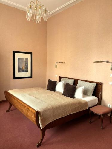 a bedroom with a large bed and a chandelier at Hotel Villa Hentzel in Weimar