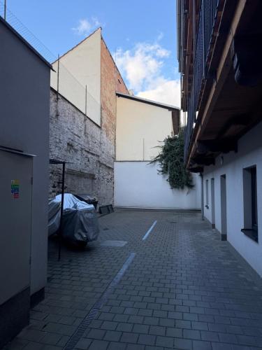 an alley with a white wall and a building at Apartmán v blízkosti centra Brna in Brno