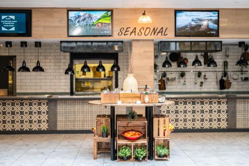a restaurant with a table in front of a counter at Kents Hill Park Training & Conference Centre in Milton Keynes