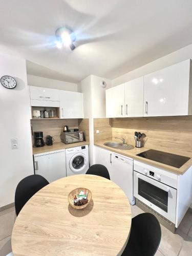 une cuisine avec une table en bois et une salle à manger dans l'établissement T2 dans résidence calme - proche des thermes et du centre, à Châtel-Guyon