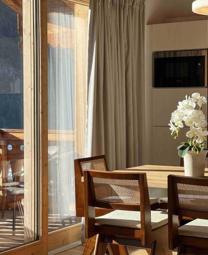 a dining room with a table and chairs and a window at AlpenPura - Chalet mit Sauna und Panoramablick in Neukirchen am Großvenediger