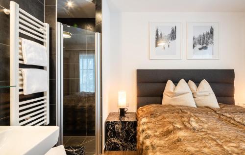 a bedroom with a large bed and a shower at AlpenPura - Chalet mit Sauna und Panoramablick in Neukirchen am Großvenediger