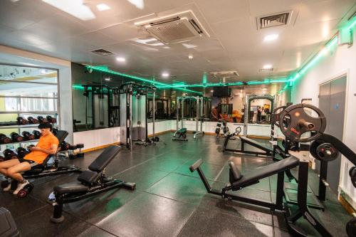 a gym with cardio equipment and a man sitting on machines at Kents Hill Park Training & Conference Centre in Milton Keynes