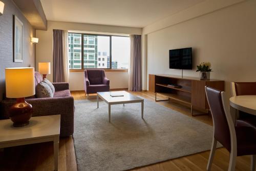 a living room with a couch and a tv at Altis Suites Apartamentos Turísticos in Lisbon