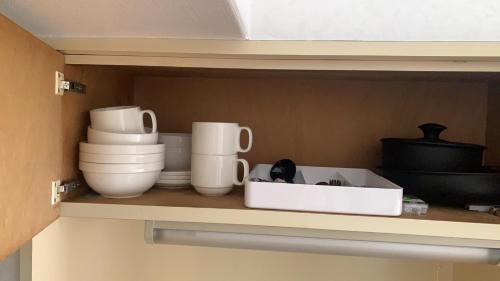 a shelf with bowls and other dishes in a kitchen at 日韓マンション305 in Tokyo