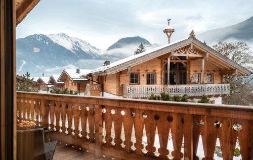 a house on a balcony with snow covered mountains at AlpenPura - Chalet mit Sauna und Panoramablick in Neukirchen am Großvenediger