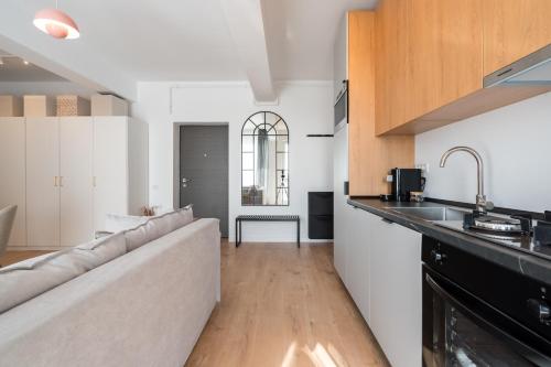 a living room with a couch and a kitchen at AeroPrime - LOFT in Tunari