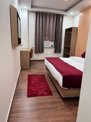 a bedroom with a bed and a red rug at Hotel The Rise At Delhi Airport in New Delhi