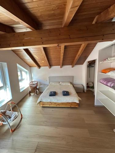 a bedroom with a large bed in a room with wooden ceilings at Nave San Rocco, Trentino in Nave San Rocco