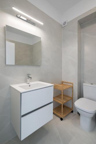 a bathroom with a white sink and a toilet at AeroPrime - LOFT in Tunari