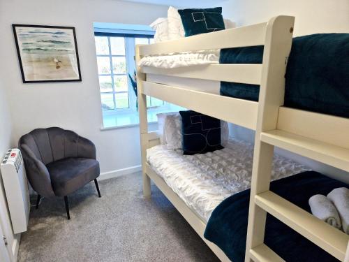 a bedroom with two bunk beds and a chair at Idyllic location, Amazing view, Spacious in Marazion