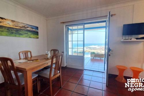 a dining room with a table and a view of the ocean at Casa da Maresia by PontaNegraAzores in Biscoitos