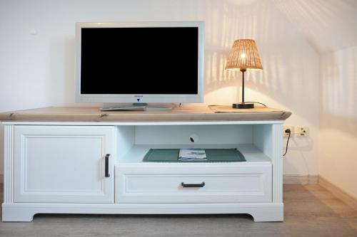 a white cabinet with a tv on top of it at Gästehaus Bi de Ley in Langeneß