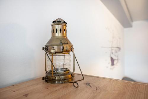 an old lantern sitting on top of a wooden table at Gästehaus Bi de Ley in Langeneß