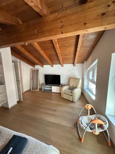 a large living room with wooden ceilings and a couch at Nave San Rocco, Trentino in Nave San Rocco