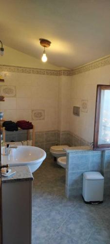 a bathroom with two sinks and a tub and a toilet at La sosta di Fano in Reggello