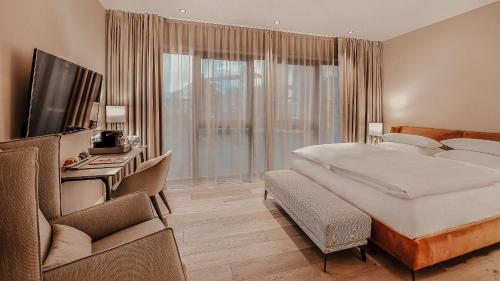 a hotel room with a bed and a tv and a window at Hotel Villa Toskana in Leimen