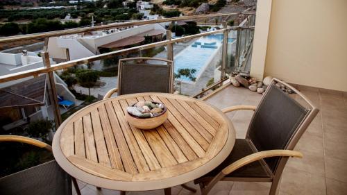 a wooden table with a bowl of rocks on a balcony at Lagada Resort in Makry Gialos