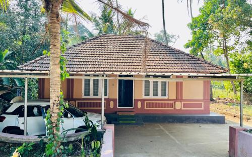 a small house with a car parked in front of it at Arapura Veedu Heritage Homestay in Kizhillam