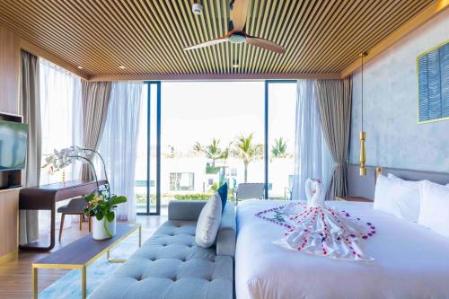 - une chambre avec un grand lit recouvert d'un cygne dans l'établissement Hoi An Wyndham Beachfront Resort 3 bedroom pool villa, à Hà Quảng (1)