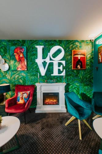 a living room with two chairs and a fireplace at Arena Deluxe & Spa in Szeged