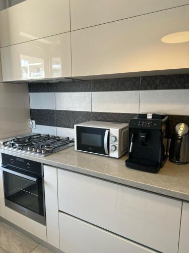 a kitchen with a microwave and a coffee maker at Alex MNL lux Apartment 2 free parking in Bucharest