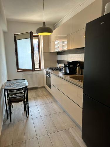 a kitchen with a table and a black refrigerator at Alex MNL lux Apartment 2 free parking in Bucharest