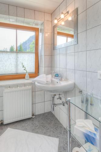 a bathroom with a sink and a mirror and a window at Michelerhof - kinderfreie Unterkunft in Lavant