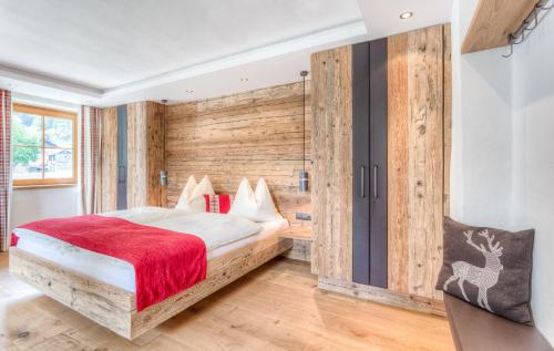 a bedroom with a bed with a wooden wall at Michelerhof - kinderfreie Unterkunft in Lavant