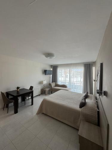 a bedroom with a bed and a table and a desk at Marianna Hotel Apartments in Limassol