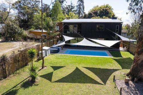a backyard with a swimming pool and a house at Beach house with heated pool and jacuzzi in Villa Argentina