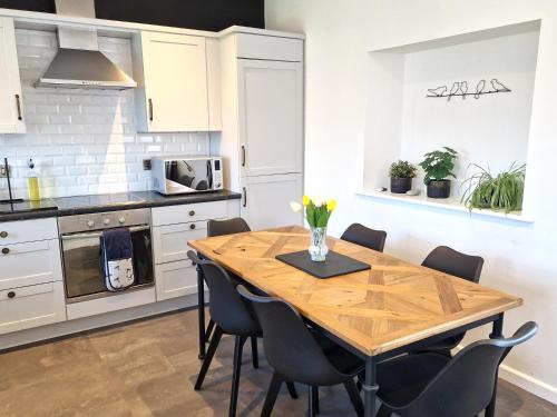 a kitchen with a wooden table and chairs at Very Spacious, Great location. Castle and Sea view in Marazion
