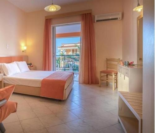 een slaapkamer met een bed en een groot raam bij The Dream Hotel in Tragaki