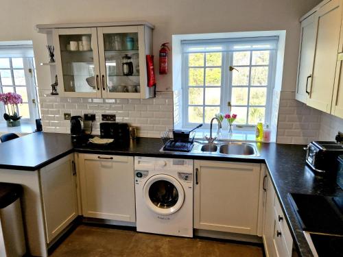 a kitchen with a washing machine and a sink at Very Spacious, Great location. Castle and Sea view in Marazion