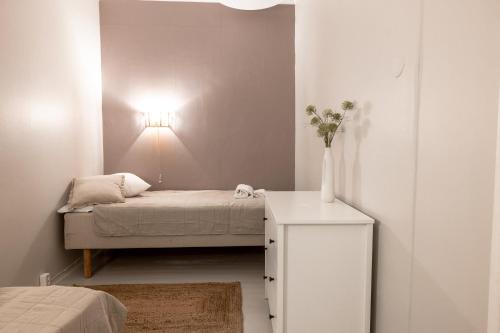 a small bedroom with a bed and a vase on a table at Spacious 5BR Apartment with Best Location in Kamppi in Helsinki