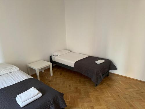 Una pequeña habitación con dos camas y una mesa. en Apartamenty 650 metrów od Dworca, en Przemyśl