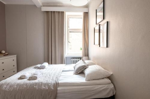 a bedroom with a white bed with towels on it at Spacious 5BR Apartment with Best Location in Kamppi in Helsinki