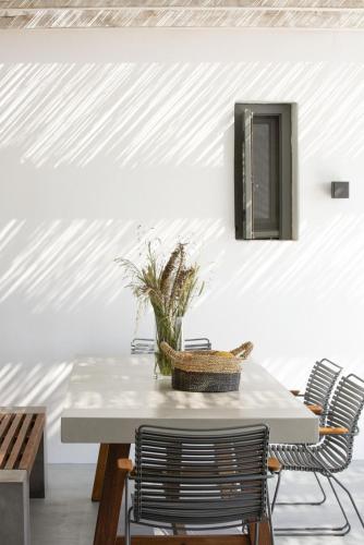 a dining room with a white table and chairs at House G in Kardiani Tinos in Kardiani