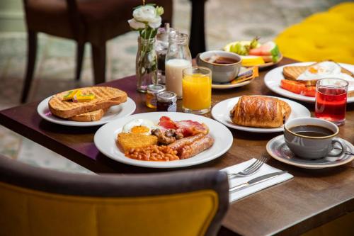 a table with plates of breakfast food on it at Wotton House in Dorking