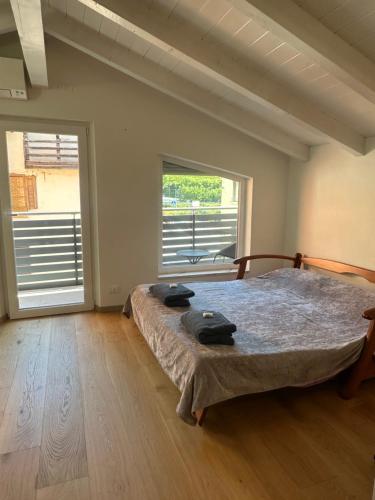 a bedroom with a large bed and a large window at Nave San Rocco, Trentino in Nave San Rocco