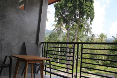 a room with a table and a balcony with a view at Yangyai Garden Hotel in Koh Phangan