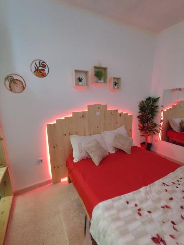 a bedroom with a large bed with a red blanket at Love room jacuzzi in Say