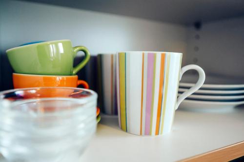 two coffee mugs and plates on a counter at Ferienwohnung Stadtplatz 25 in Traunstein